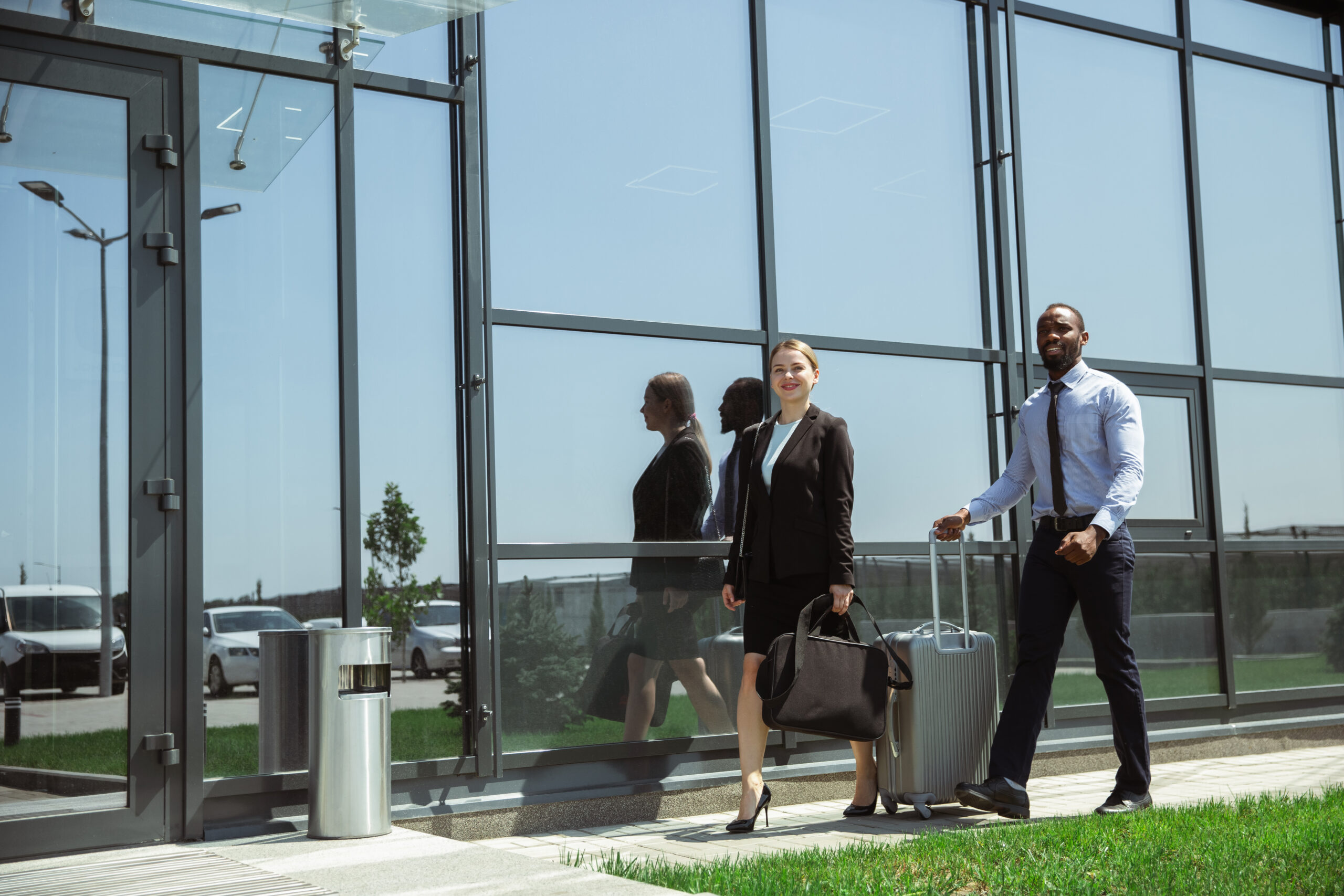 Young businessman waiting for departure in airport, work trip, business lifestyle. Man and woman with gadgets before starting their vacation, registration. Working in special waiting zone together.